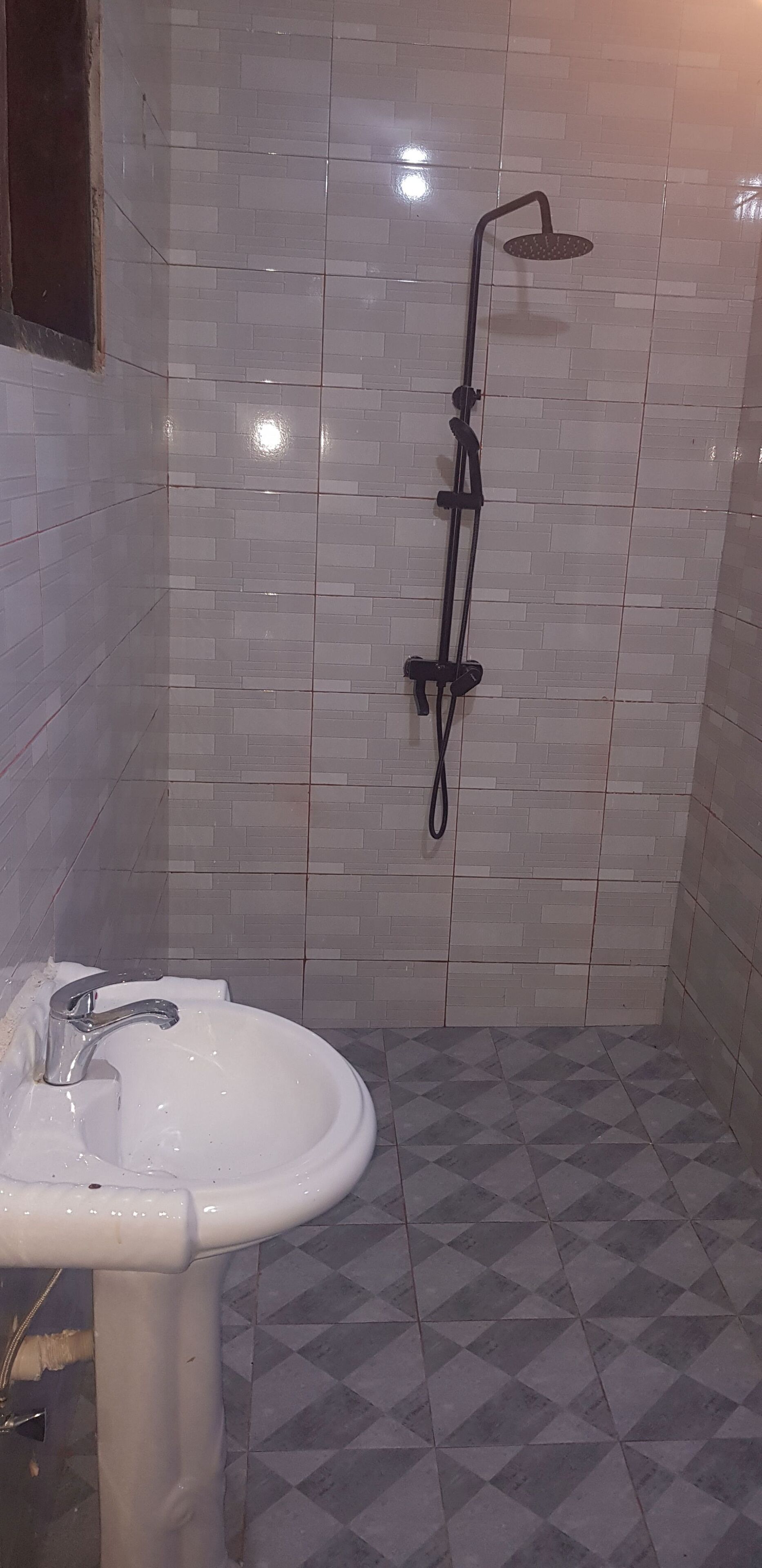 Portrait view of a tiled shower and basin