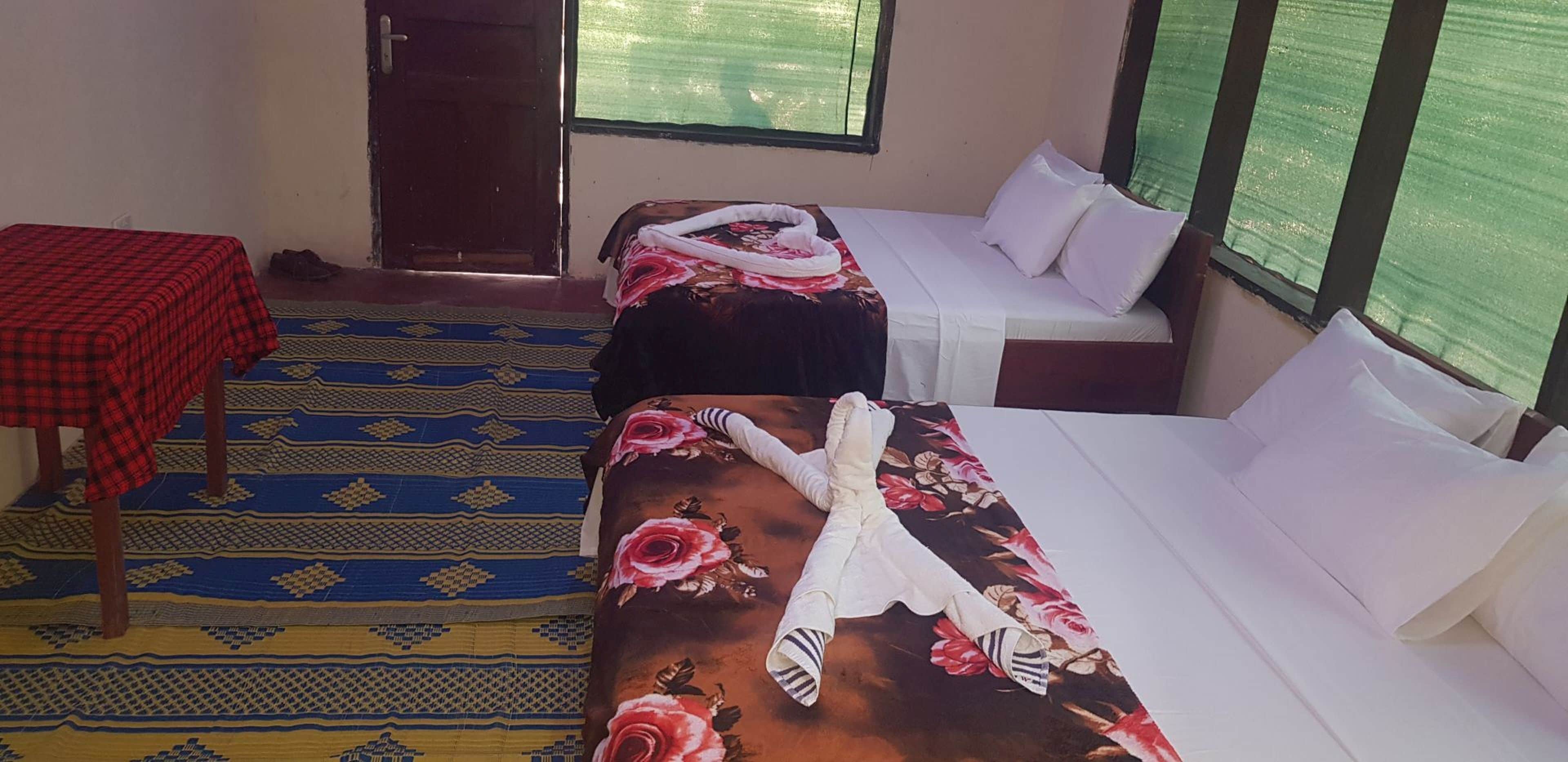 Room interior with two visible beds, a rug and a small table