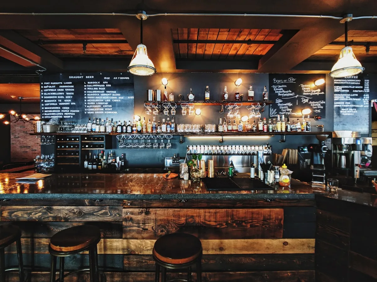 A bar counter with drinks and glassware